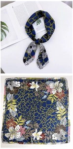 Detail of a square silk scarf with navy giraffe print and floral pattern borders