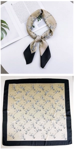 Detail of champagne gold square silk scarf featuring zebra print and black border finish