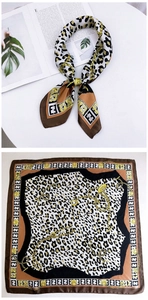 Detail of silk square scarf featuring classic leopard print and golden chain pattern design