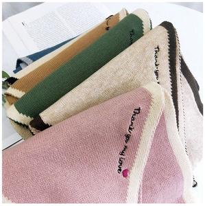 Detailed view of knitted scarves with 'Thank you my love' embroidery in five colors