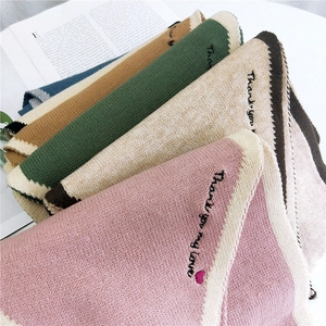 Knitted winter scarves in multiple colors featuring decorative heart embroidery detail