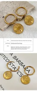 Detail of 1.7cm golden stainless steel hoop earrings with sunburst pendant and 18K plating