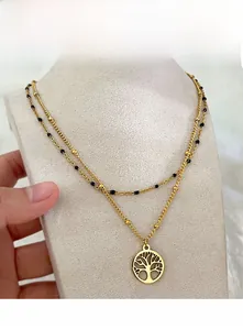 Dettaglio collana doppio strato placcata oro 18k con ciondolo albero della vita e perline nere