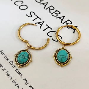 Vintage gold oval stainless steel hoop earrings with turquoise stones on white background