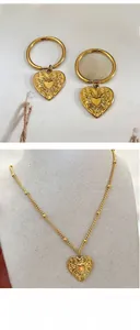 Detailed view of gold heart pendants with embossed star and sunray patterns on jewelry