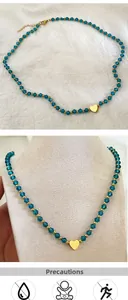 Détail du collier avec perles de cristal bleu et pendentif coeur doré élégant