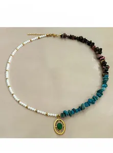 Detail of asymmetrical necklace with colorful natural stones, pearls and a gold pendant