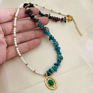 Bohemian pearl necklace with colorful gravel stones and green oval pendant on hand