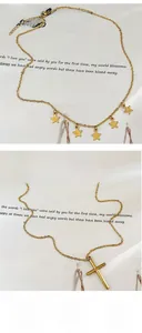 Detail of layered gold star necklace and minimalist cross pendant with lobster clasp