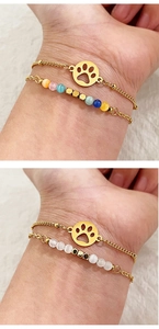 Detail view of gold-plated paw charm bracelet set with cat eye stones and zircon beads