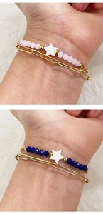 Close-up of layered 18K gold stainless steel bracelets with stars and colorful stone beads