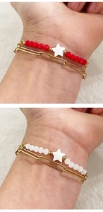 Detail of double-layer 18K gold stainless steel bracelet with red beads and star charm