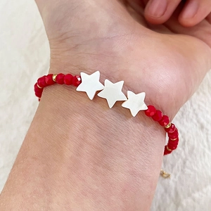 Handmade beaded bracelet with red crystal beads and white shell stars on gold chain