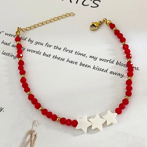 Handmade beaded bracelet with red faceted beads and three white shell star charms