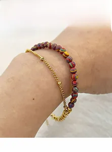 Detail of layered gold beaded chain and colorful stone beads on a bohemian bracelet