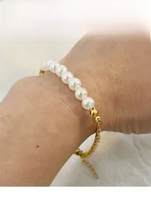 Close-up of pearl and gold chain bracelet on wrist with adjustable extender link