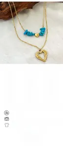 Detail view of double-layered gold necklace with turquoise stones and heart pendant