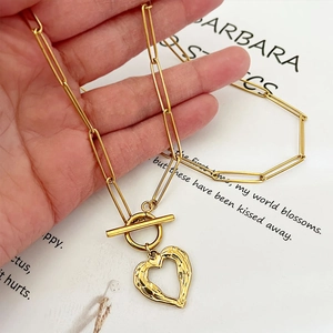 Collana a catena dorata con ciondolo a cuore testurizzato e chiusura a levetta