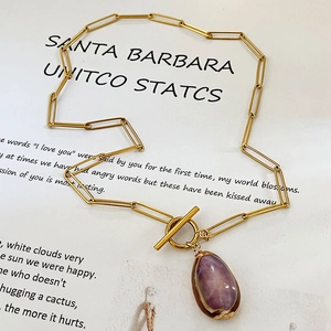 Collana bohemian a catena d'oro con pendente in gemma viola e chiusura a barra T