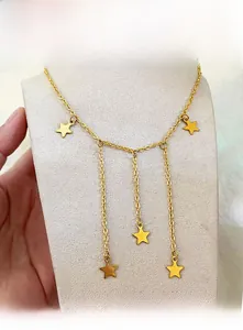 Detail of gold star tassel necklace featuring multiple dangling pentagon charms