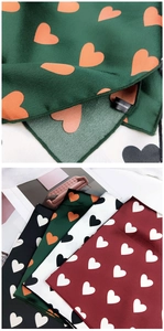 Gros plan sur la texture du foulard à cœurs et l'étiquette en 100% polyester de haute qualité