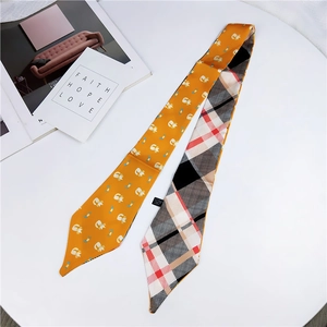 Detail of yellow silk twilly scarf featuring cartoon cats and classic plaid pattern