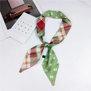 Detail of slim satin scarf with cat print and vintage plaid pattern on white background