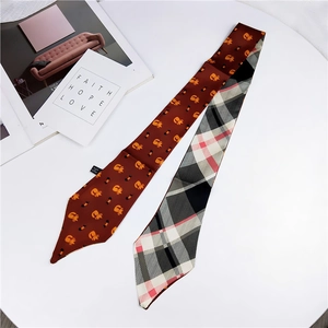 Detail of a double-sided twilly scarf featuring cute cat patterns and classic plaid texture