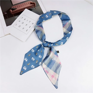 Cartoon cat and plaid double-sided skinny scarf for women shown on a white tabletop