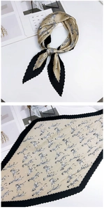 Gros plan du foulard en soie plissée avec imprimé zèbre doré et bordure en dentelure