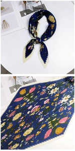Détail d'un foulard en soie plissé avec imprimés floraux et texture plissée bleu marine