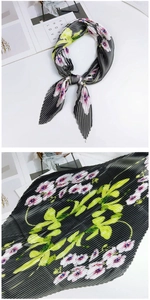 Détail d'un foulard plissé en soie avec motifs floraux roses sur tissu gris foncé