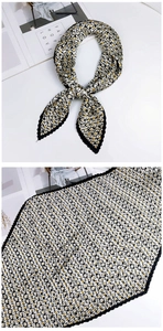 Détail d'un foulard en soie plissé aux motifs géométriques noir blanc et jaune