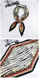 Détail d'un foulard en soie plissé avec rayures diagonales noires et blanches et bords colorés