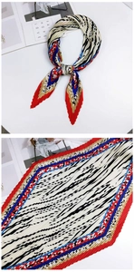 Détail du foulard plissé en soie avec motifs géométriques rouges, bleus et noirs