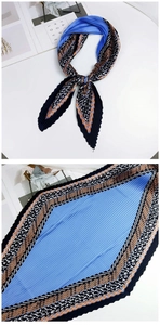 Détail d'un foulard en soie plissé bleu roi avec motifs floraux et géométriques