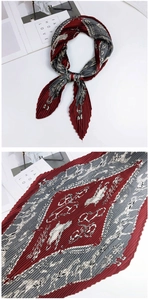 Détail d'un foulard en soie plissé avec des imprimés équestres et des motifs de mors chic