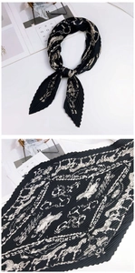 Détail du foulard plissé en soie noire avec imprimé vintage de chevaux et carrosses