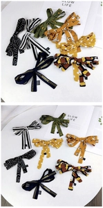 Detail view of various patterned silk scarves and 100% viscose labels on a white table