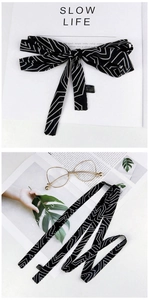 Detail of a black and white geometric silk scarf made of 100% polyester material