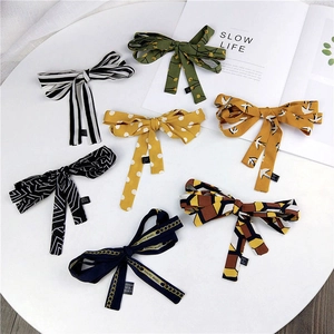 Flat lay of seven stylish skinny silk scarves featuring polka dots and floral patterns
