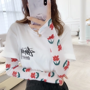 Women's mesh sun protection sleeves with red floral pattern worn under white t-shirt
