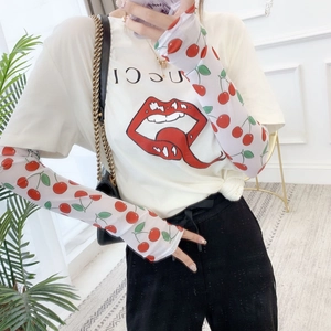 Detail of white mesh sun sleeves featuring red cherry patterns on model arm