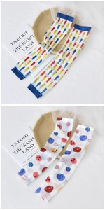 Detail of sun protection sleeves featuring colorful fish print and happy smile pattern