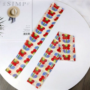 Detailed view of mesh sun protection sleeves with vibrant red flower prints and soft ice silk