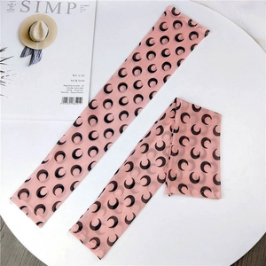 Close-up of pink mesh sun sleeves with black crescent moon print for sun protection