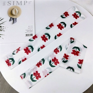 Detail of white mesh sun protection sleeves featuring a delicate red floral pattern