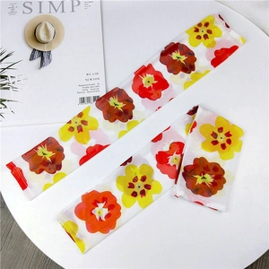 Detail view of thin mesh sun protection sleeves with vibrant floral prints on white fabric