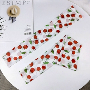 Detailed view of mesh sun protection sleeves with cute red cherry prints and lace trim