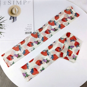 Close-up of breathable mesh sun sleeves with strawberry prints and Hello pattern